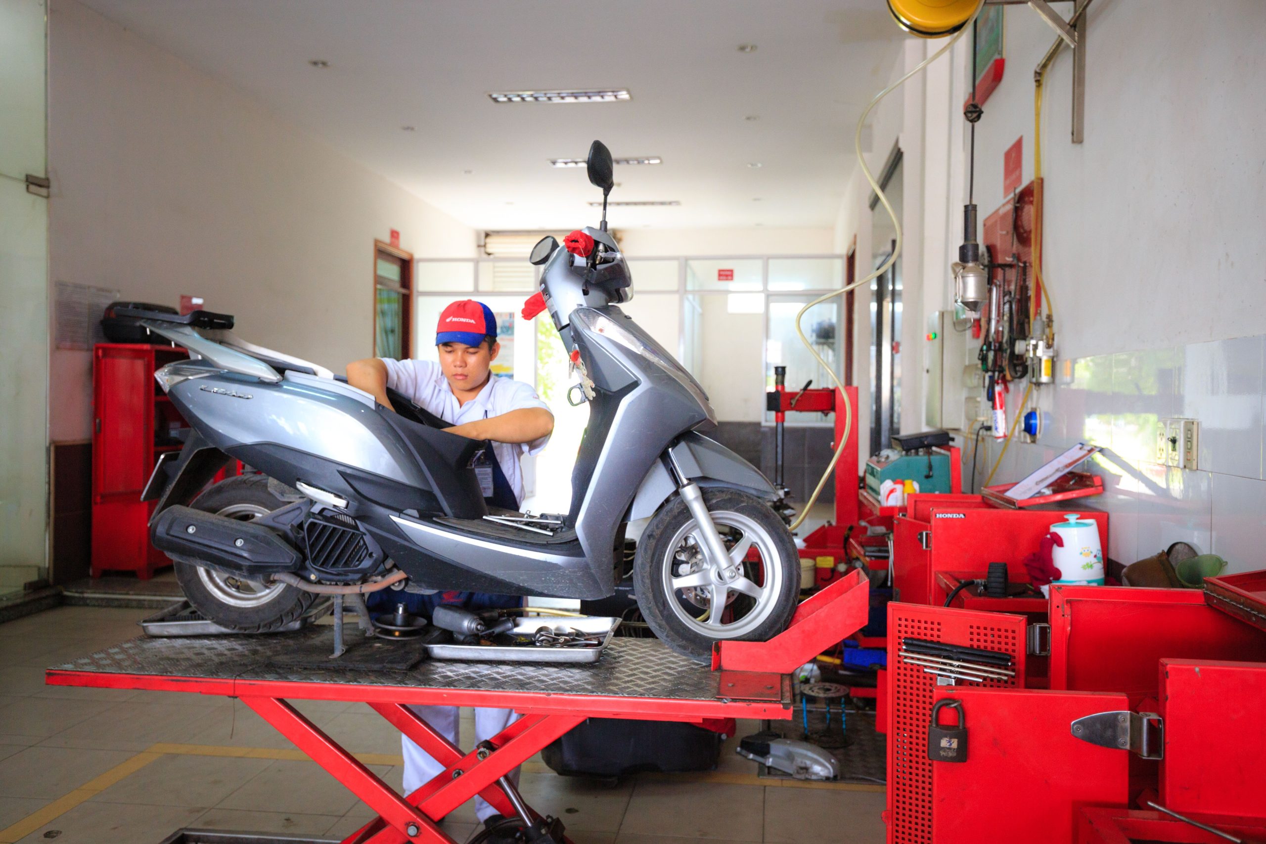Mécanicien effectuant maintenance sur scooter