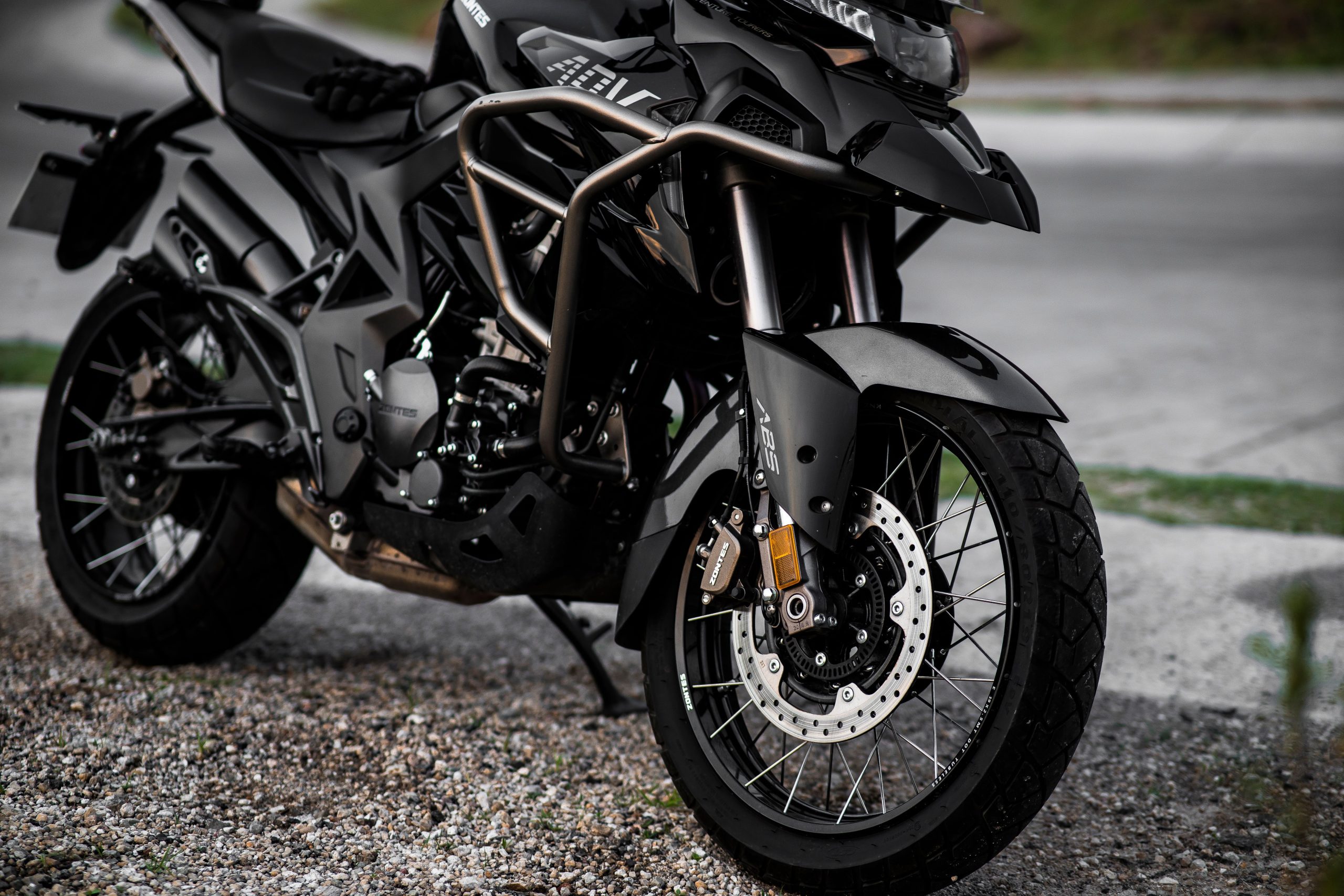Moto noire stationnée route gravier