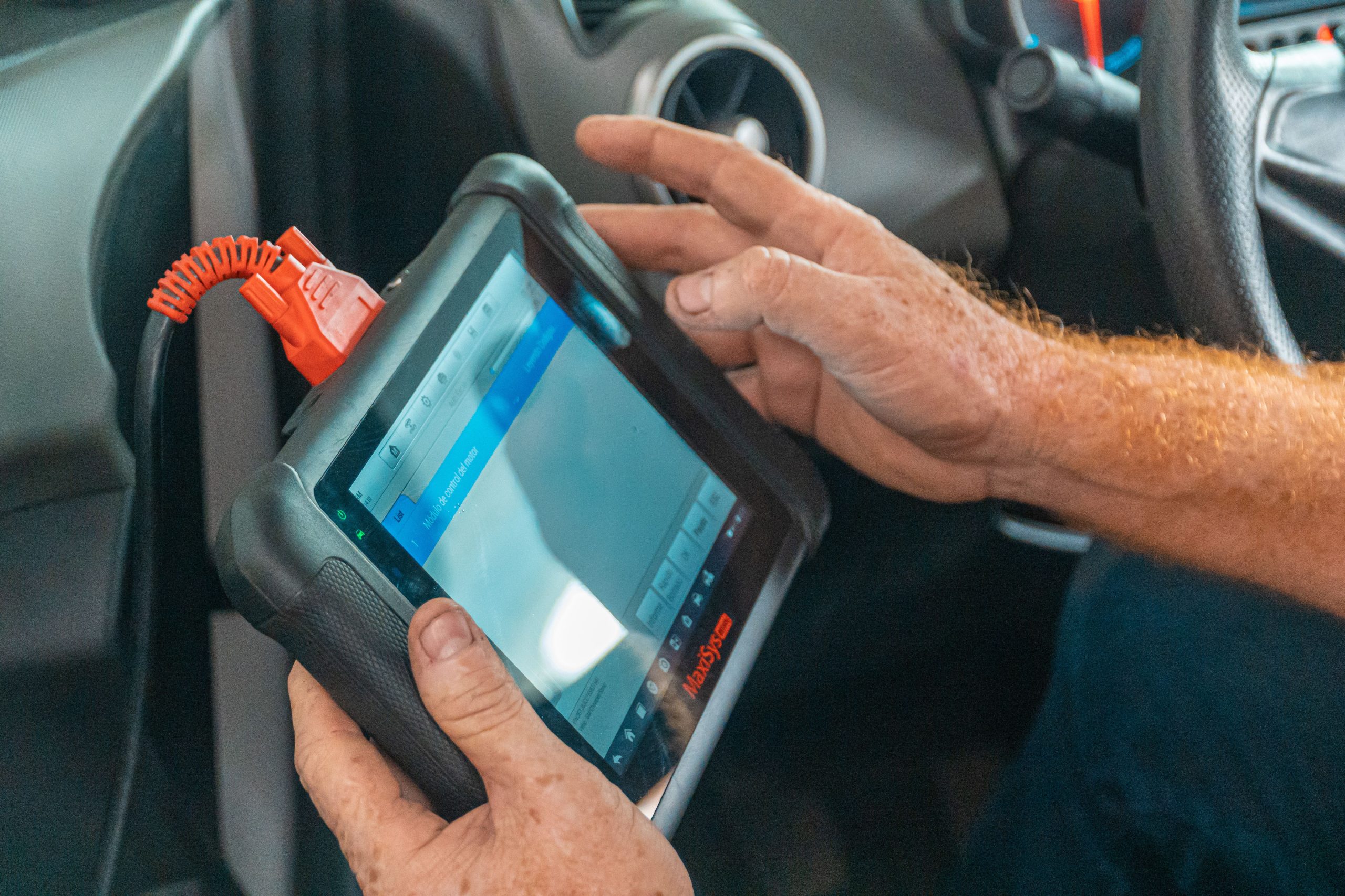 Mécanicien utilisant tablette diagnostic dans un véhicule