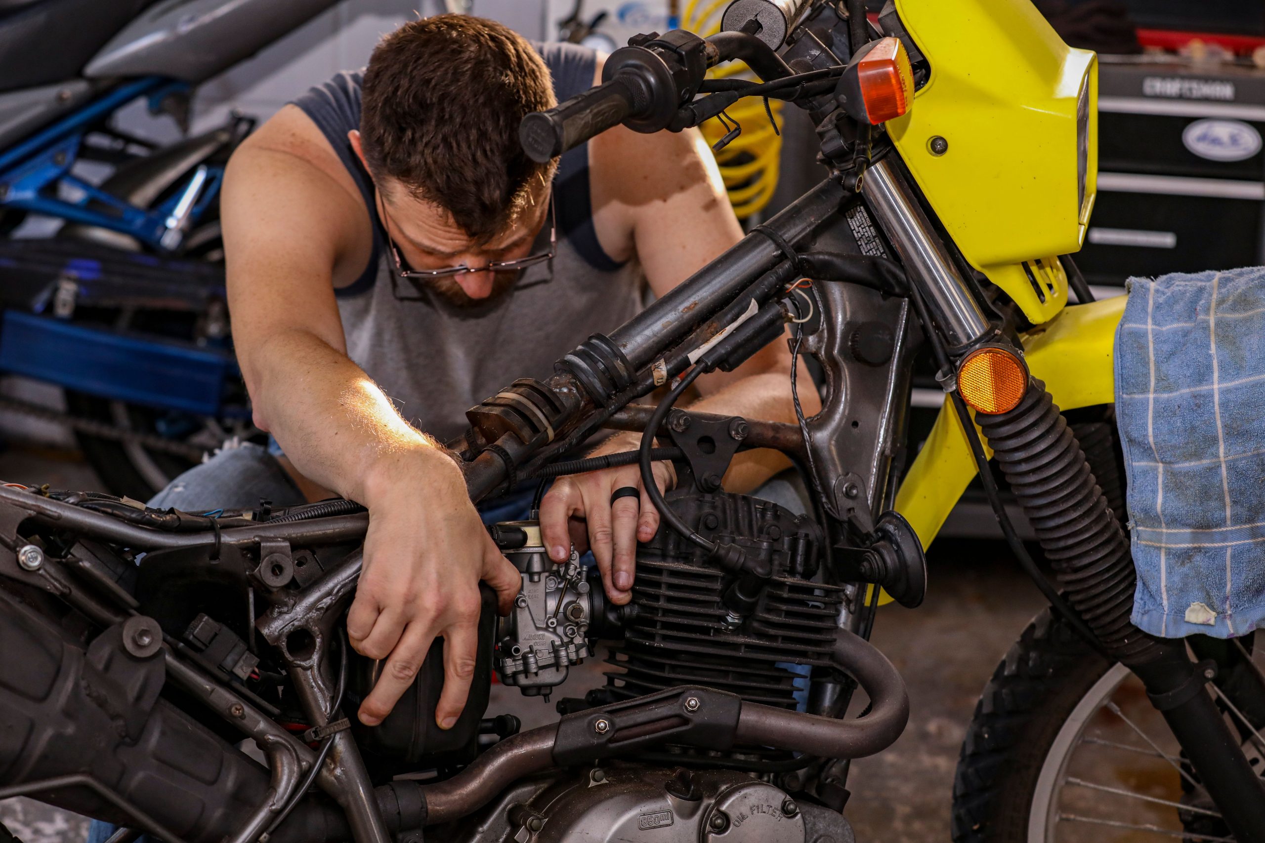 Mécanicien réparant moteur moto en atelier