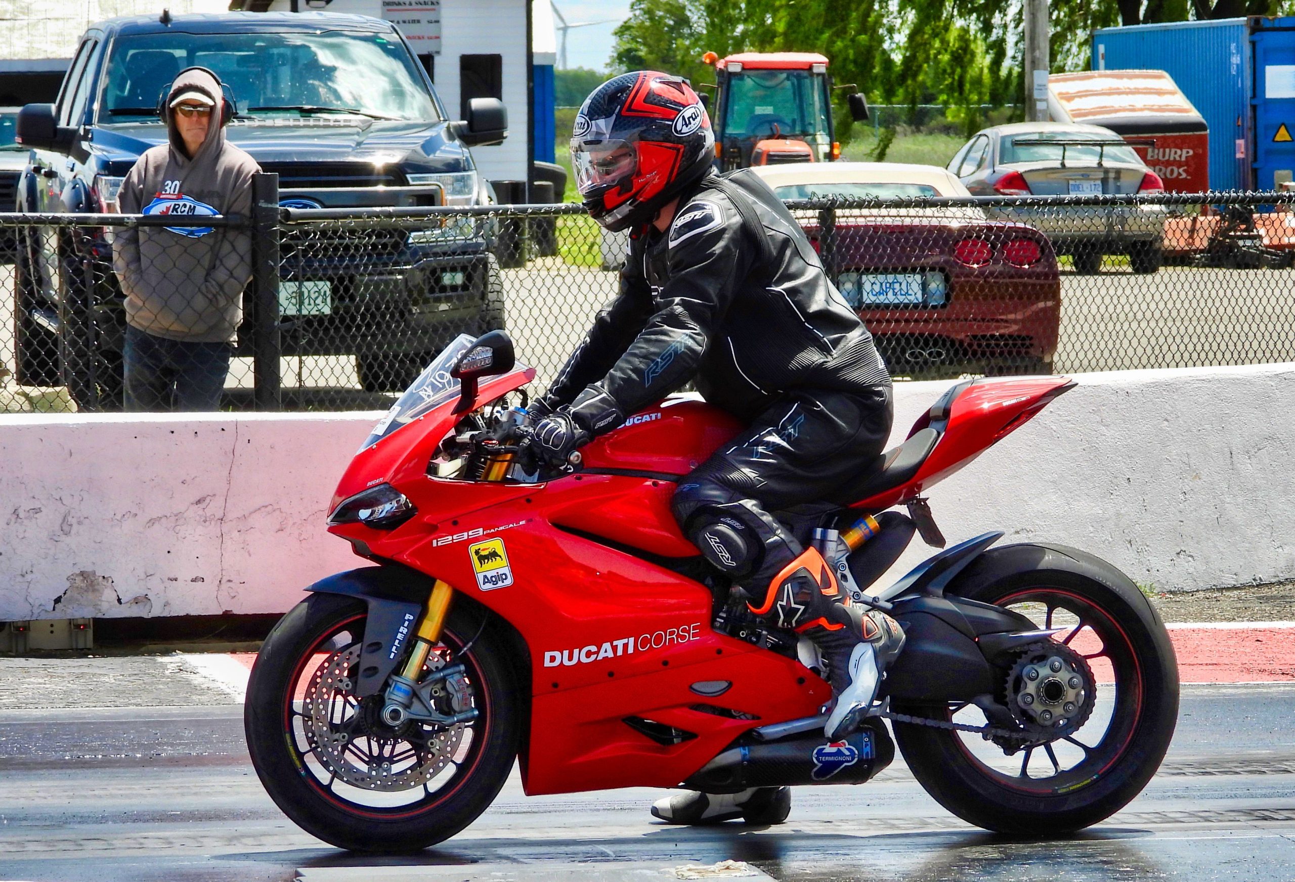 Motard en tenue racing accélère sur Ducati rouge