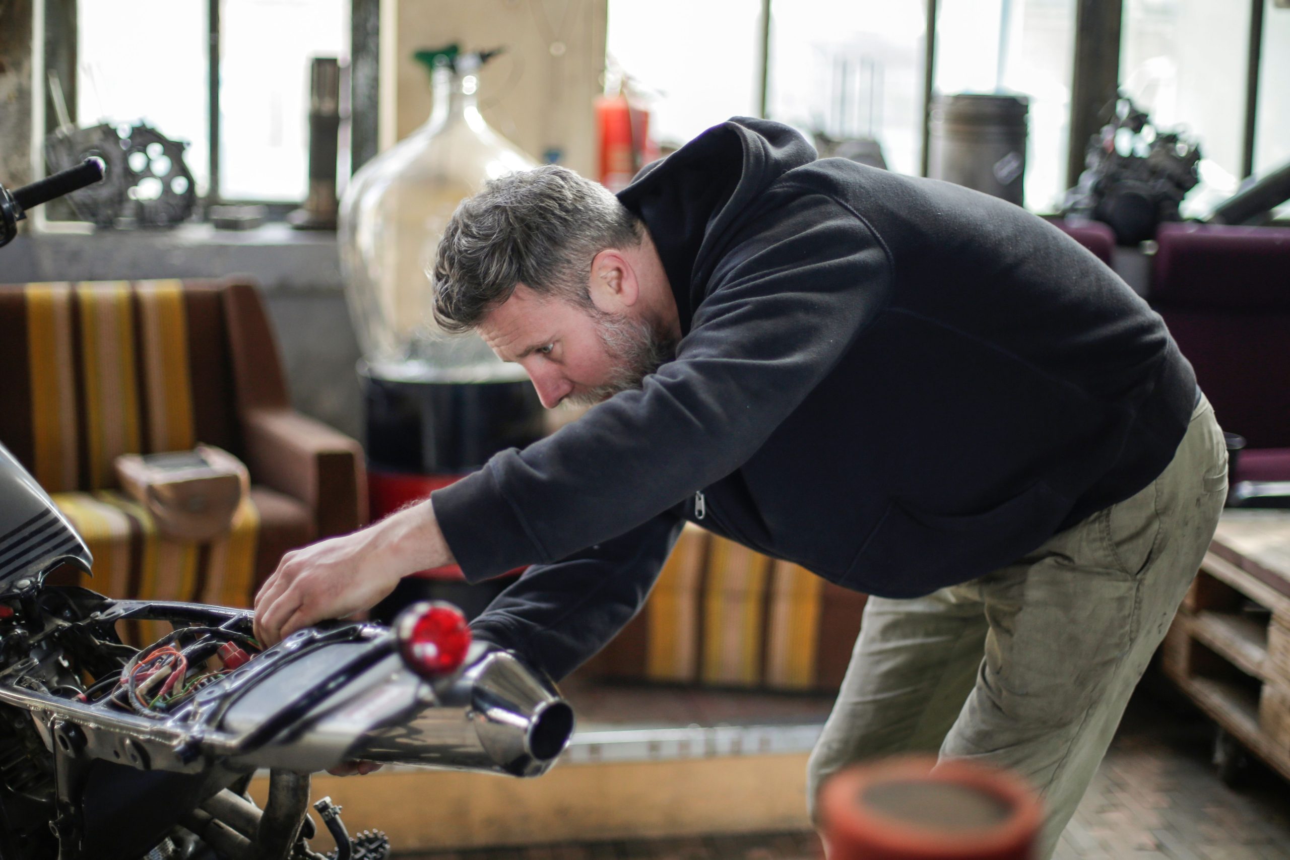 Mécanicien barbu inspectant détails électriques moto Guzzi