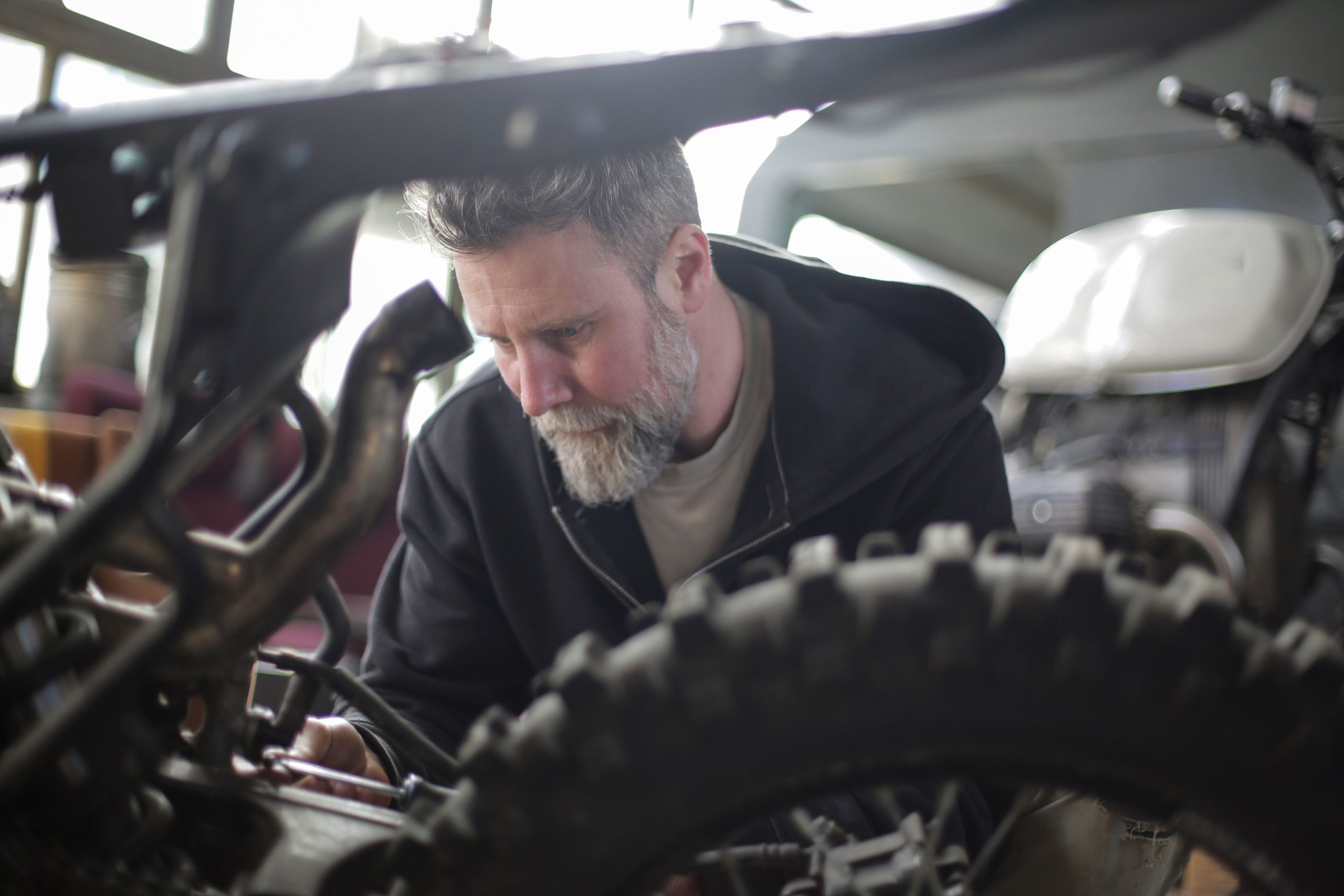 Mécanicien réparant moto avec tournevis garage moderne